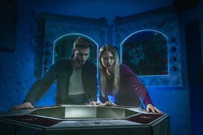 Frau und Mann in einem blauen Escape Room