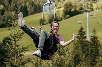 Man posiert bei Flug mit der Zipline Annaberg.