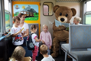 Spielwagen im Ötscherbär, Kinder mit Büchern und Maskottchen