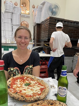 Sabrina sitzt in der L'Antica Pizzeria da Michele mit einer Pizza Margherita vor sich
