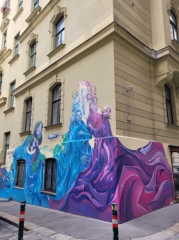 Violette und blaue Gestalten auf Hausmauer gemalt