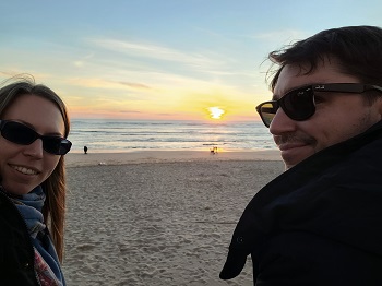 Pärchen mit Sonnenbrillen am Strand bei Sonnenuntergang in Andalusien