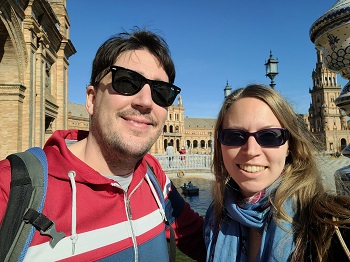 Lächelndes Pärchen mit Sonnenbrillen auf der Plaza de España in Sevilla