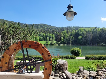 Altes Mühlrad vor Teich am Waldrand auf der ersten Etappe am Wörthersee Rundwanderweg