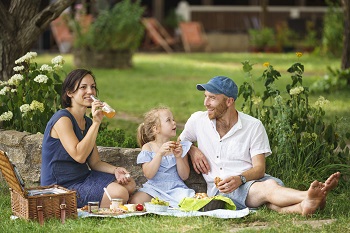 Familie beim Picknick im Garten beim Biobauern ADAMAH