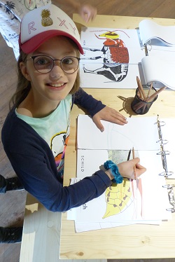 Mädchen malt im Klapp-Bilderbuch der Donau-Auen