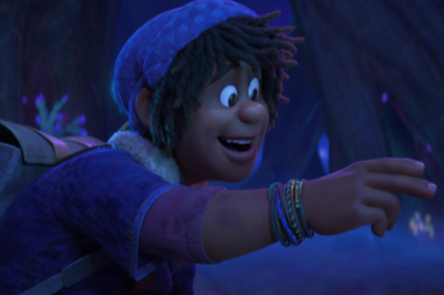 Ein junger, schwarzer Bub mit dunklen Haaren trägt eine blaue Haube, Jacke und ein Armband aus dem Film Strange World