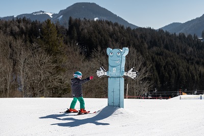 Kleine Skifahrerin vor Figur zum Abklatschen im Anna Park