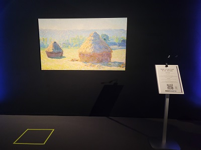 Bild in schwarzem Raum mit Bodenmarkierung und Aufsteller bei Monets Garten Ausstellung in Wien