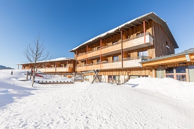 Das JUFA Hotel Annaberg im verschneiten Winter in der Sonne