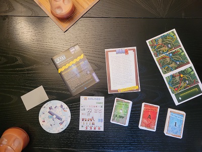 Das Material des Exit Spiels bestehend aus Karten, Dekodierscheibe und so gennanten seltsamen Teilen