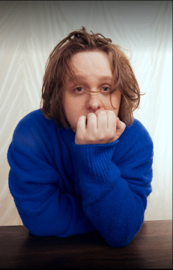 Lewis Capaldi stützt sich mit einem Arm ab.