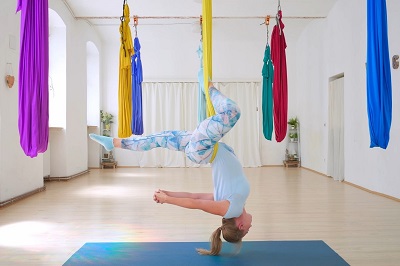 Frau in Umkehrhaltung auf einem Aerial Yoga Tuch