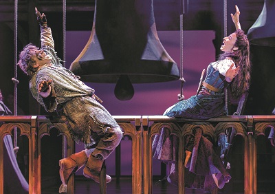 Quasimodo und Esmeralda singen sitzend auf der Brüstung des Glockenturms beim Musical in Wien