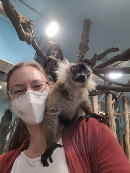 Frau mit Maske hat Vari auf Schulter