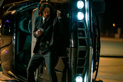 John Wick geht hinter einem Wagen in Deckung