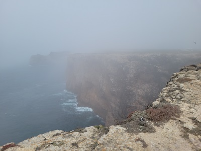 Neblige Felsküste der Algarve am Atlantik