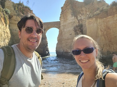 Daniel und Sabrina vor einer Steinbrücke, die über das Meer zwei Felsen verbindet