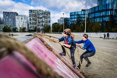 Vater und Tochter auf einer rutschigen Kletterrampe mit Seil beim Xletix Kids auf der Trabrennbahn Krieau