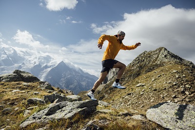 Florian Grasel springt von einem großen Stein ab beim Trailrunnung
