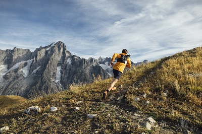 Ultratrail Läufer Florian Grasel von hinten aufgenommen, rennt den Berg hinauf