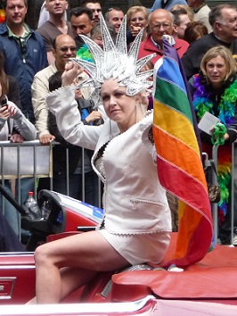 Cyndi Lauper mit Regenbogenfahne in der Hand führt eine Gay Parade an.