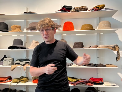 Klaus Mühlbauer vor einem Regal voller Hüte