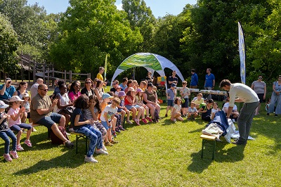 Sommerfest im Nationalparkhaus Lobau, ein Ranger präsentiert vor Sitzreihen mit Kindern und Eltern.