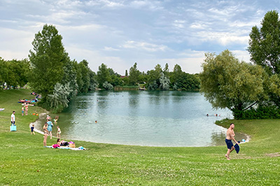 Teich, Strand, Menschen am Rand vom Teich