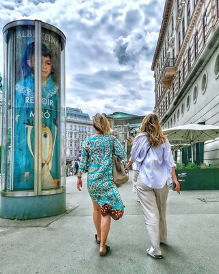Foto vor der Albertina von zwei Frauen, das türkise Kleid passt zufällig genau zur Farbe der Straßensäule 