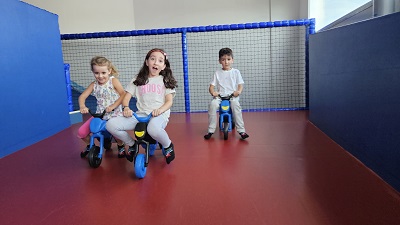 3 Kinder auf Laufrädern bzw. Rutschbikes in der Playworld