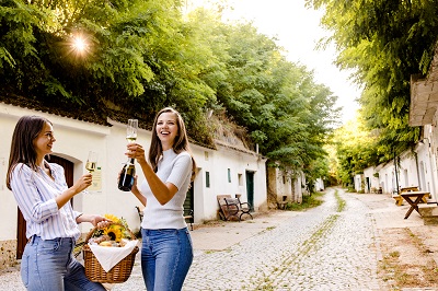 Zwei junge Frauen mit Picknickkorb und Frizzante in der Radyweg Kellergasse in Poysdorf