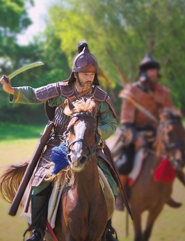 Hunne reitet in Kampfmontur und mit Schwert