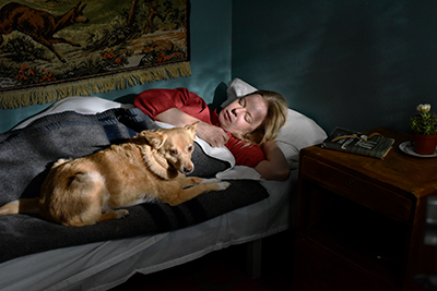 Alma Pöysti und der Hund liegen gemeinsam im Bett.