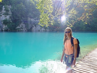 Frau im Wander Outfit auf Steg vor türkisblauem See