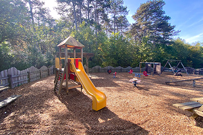 Spielplatz mit Rutsche, eingezäunt