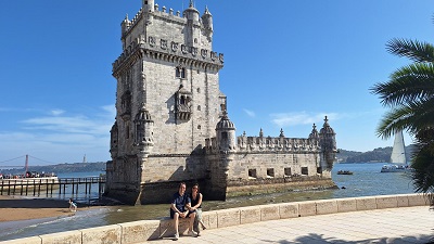 Paar sitzt vor dem Belém Turm