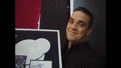 Robbie Williams freut sich über eine Platin Schallplatte