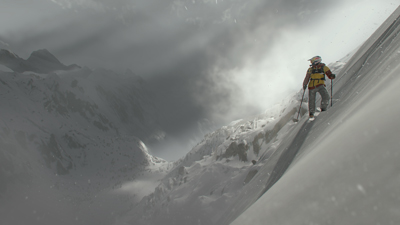 Ein Snowboarder steht allein auf einem verschneiten Berg