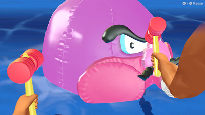 Eine Luftballoon-Version eines Oktopus-Wario vor zwei Hämmern der Spieler
