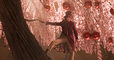 Timothée Chalamet als Willy Wonka am Schokobaum.