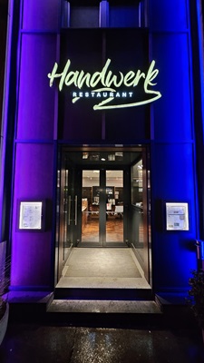 Der violett beleuchtete Eingang des Handwerk Restaurants am Wiener Gürtel