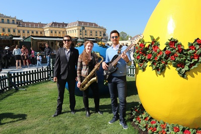Eine Jazzband steht beim Östermarkt neben einem Riesenei, im Hintergrund ist das Schloss Schönbrunn