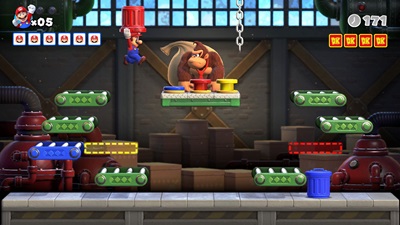 Ein Gameplay Screenshot von Mario vs. Donkey Kong. Mario springt mit einer Tonne in den Händen auf Donkey Kong zu