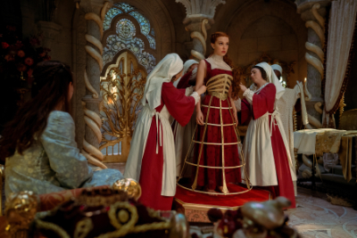 Elodie wird von mehrere Kammerzofen in ein Hochzeitskleid eingekleidet.