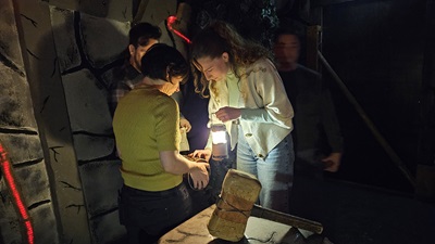 Kirstin Kriz beim Rätseln mit den Helden der Freizeit mit Lampe bei einem Schlossrätsel der Open the Door Escape Rooms