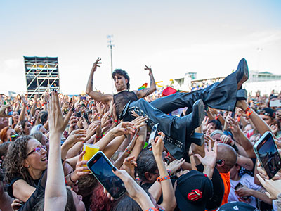 Sänger Domiano von Maneskin wird von der Crowd hochgehalten.