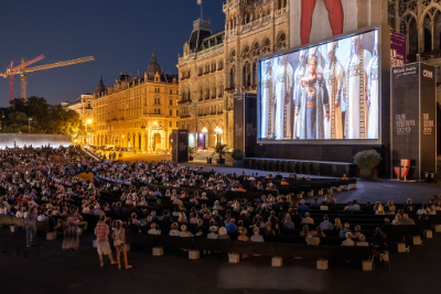 Große Leinwand vorm Wiener Rathaus. Davor sehr viele Sitzplätze in einem Halbkreis.