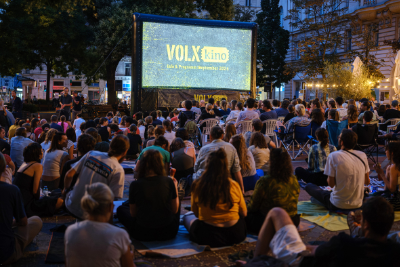 Menschenmennge vor einer Leinwand mit der Aufschrift VOLX KINO.