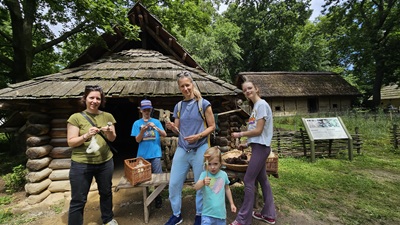 Familie beim Spinnen von Stoff im Archäologischen Freigelände in Asparn